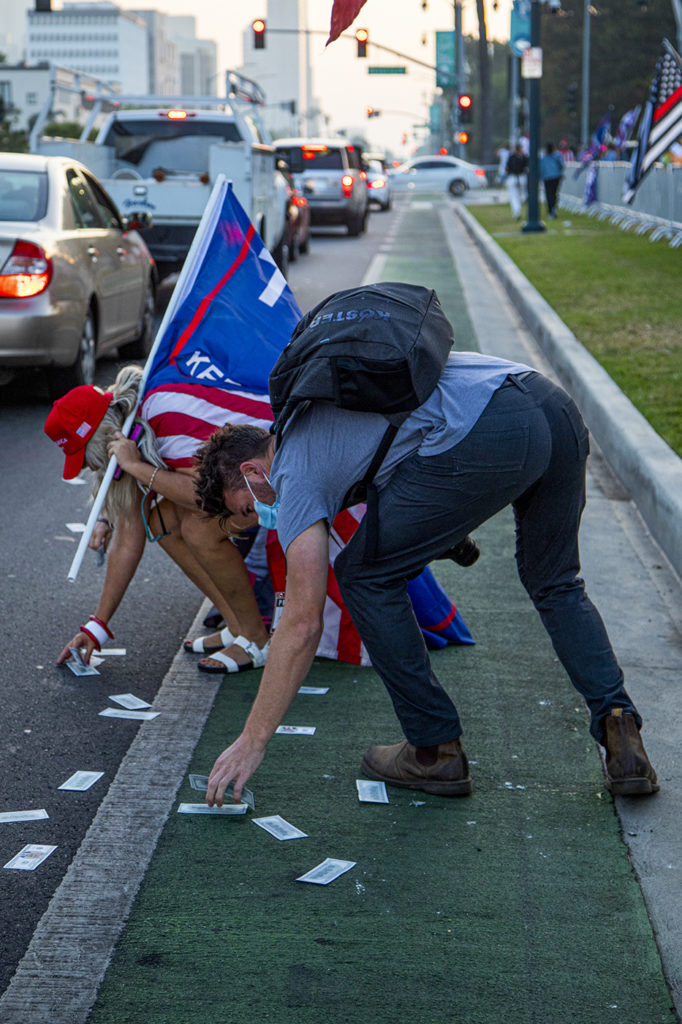 One car passing by the pro-Trump rally threw handfuls of parody Trump dollars out their window, onto the street. Trump supporters climbed over a steel barrier to pocket the novelty $2,020 bills.