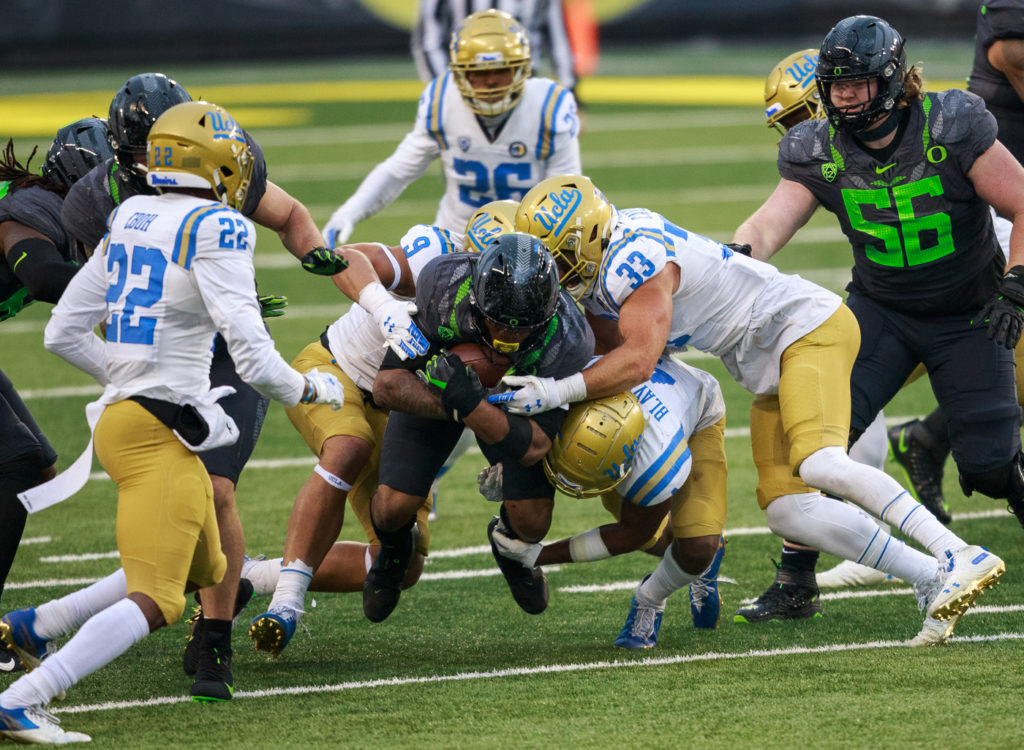 Oregon running back CJ Verdell is tackled by the Bruins' defense.