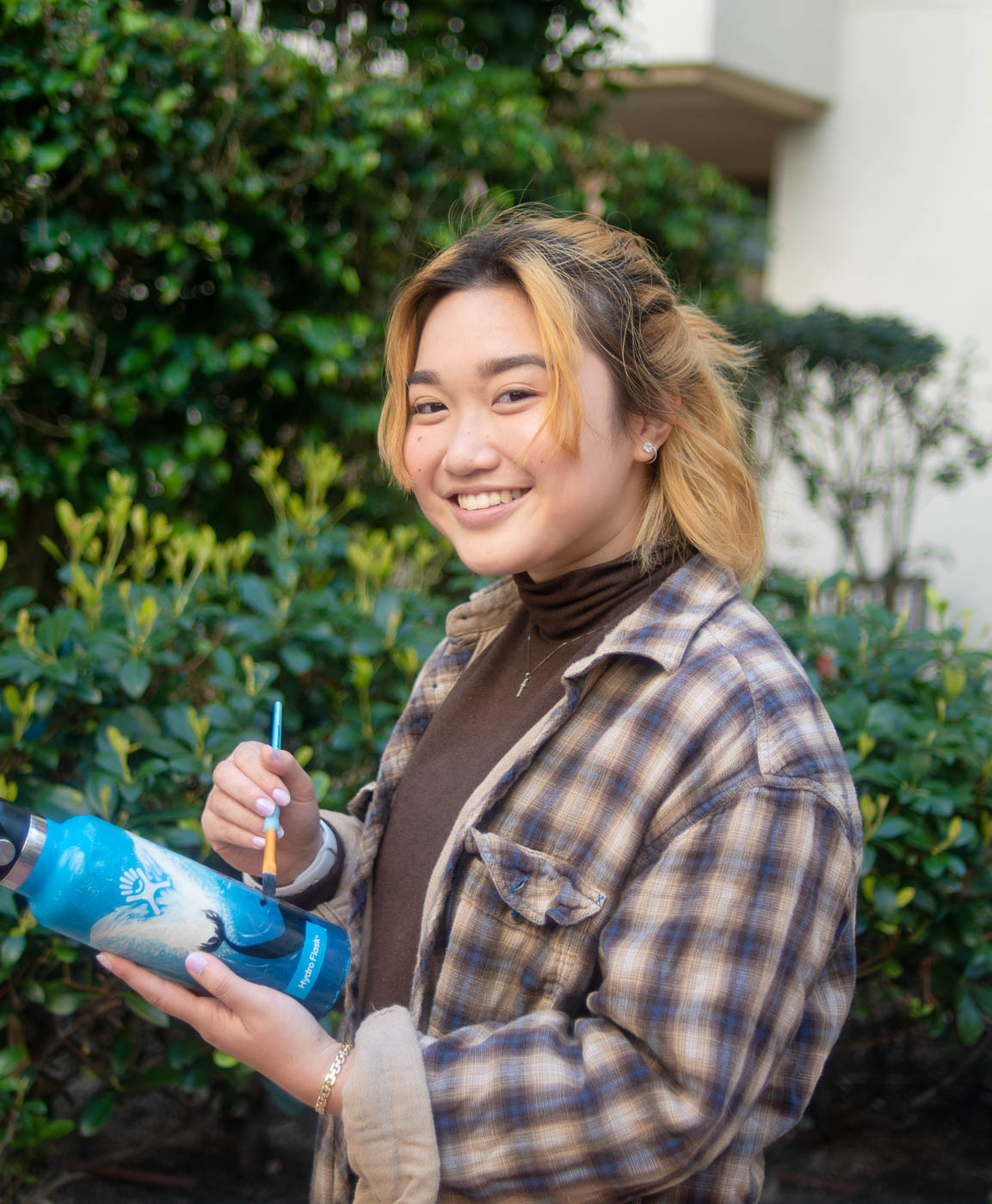 Student uses Hydro Flask bottles as canvases for her painting