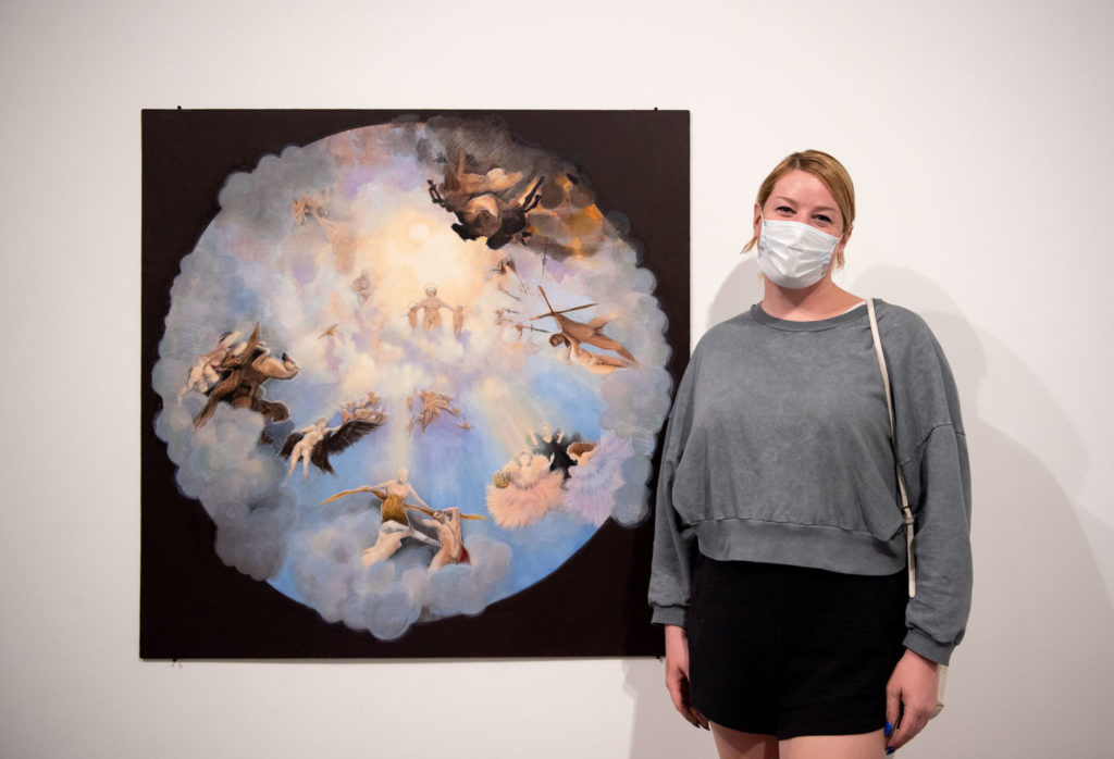 Fourth-year art student Gwyneth Bulawksy stands in front of her painting, "Ascension," which bridges Greco-Roman grandeur with trans representation. (Jefferson Alade/Daily Bruin)