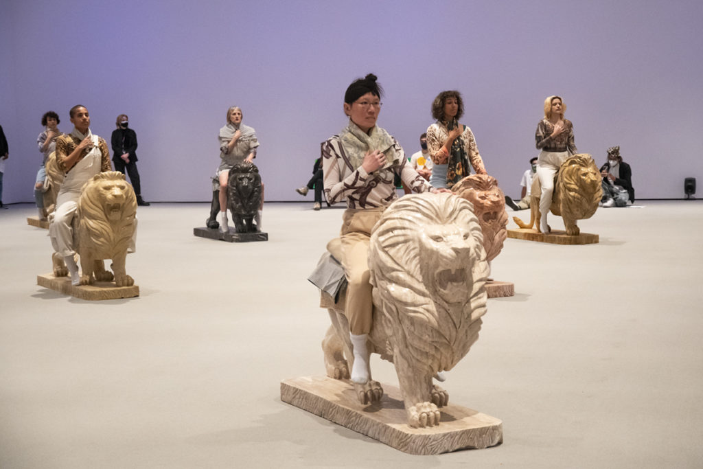 As part of the more than 50 artists&squot; collaborative show "Lifes," performers sit atop sculptures of lions. (Kyle Kotanchek/Daily Bruin)