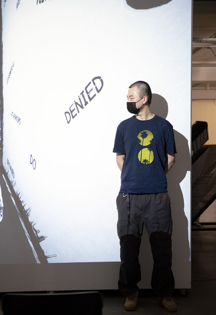Luo stands in the exhibition space at the Broad Art Center, where he is installing his works to later be displayed. The video games twist typical conventions, such as that of the horror game, into social commentary. (August Suchecki/Daily Bruin)