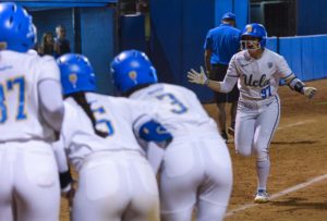 Redshirt senior infielder Delanie Wisz runs to her teammates following her grand slam home run in No. 5 seed UCLA softball’s NCAA regional opener against Grand Canyon on Friday. Wisz set a career high in RBIs, with six, in the Bruins’ mercy-rule victory at Easton Stadium. (Jack Stenzel/Daily Bruin)