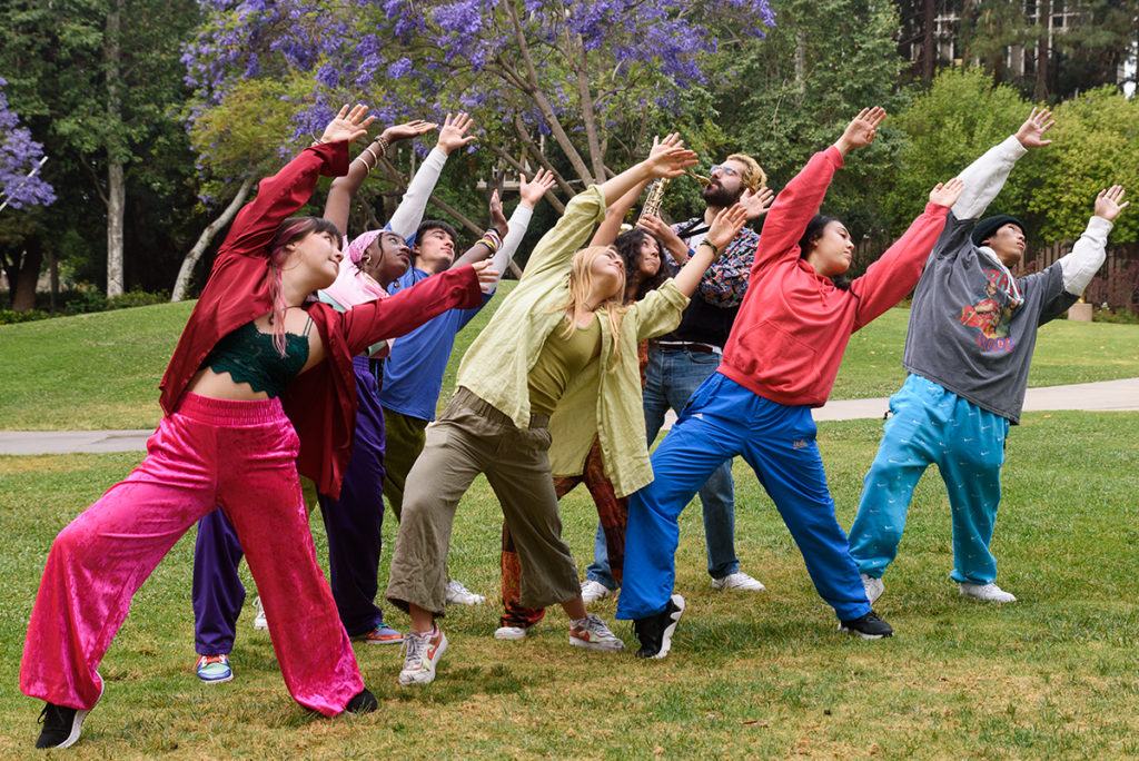 Members of Outspoken lean and outstretch their arms in unison. Third-year dance student Travis Lim and third-year dance student and artistic director Jessica Warshal co-choreographed the dance, and Warshal said the piece displays the duo's backgrounds in modern jazz and hip-hop. (Jeremy Chen/Daily Bruin staff)