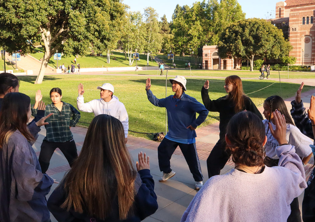 Near Wilson Plaza, ACA All Day members practice mirroring each others movements. The group's high energy set will incorporate audience interaction through the design of their formations. (Sandra Ocampo/Daily Bruin)