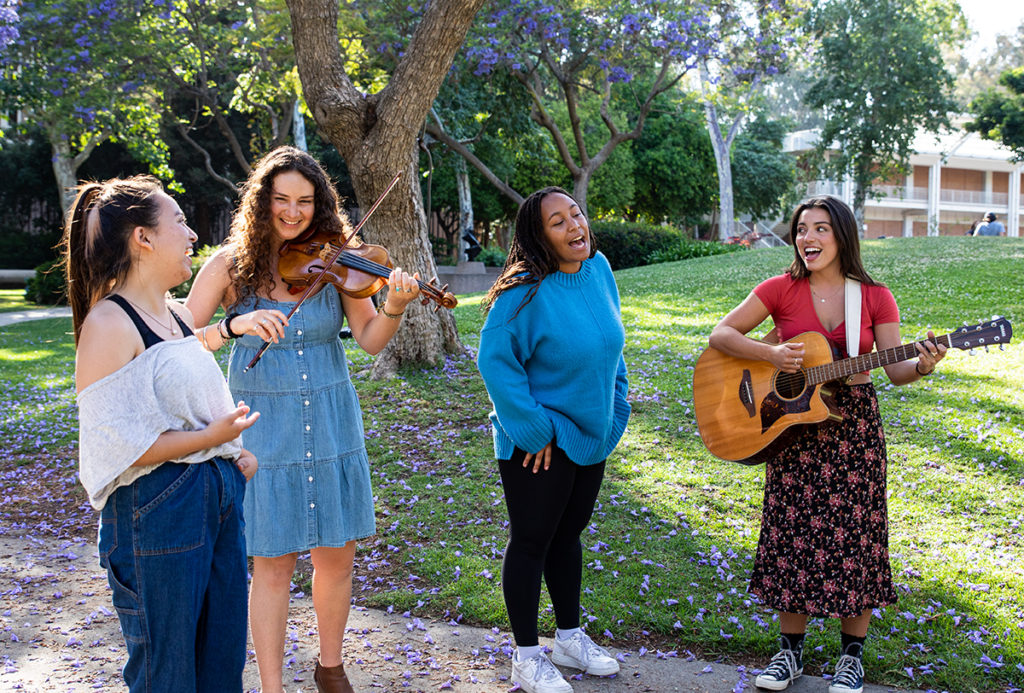 (From left to right) Williams smiles as Wingate and Shapiro play their guitar and Rhone-Collins sings. Wingate said the group aims to channel rock, folk and country while resisting representations of women seen in those genres. (Ashley Kenney/Photo editor)