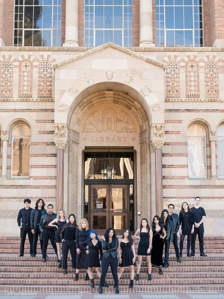 Resonance members stand in a triangular formation on the steps of Powell Library. First-year chemical engineering student Kelsey Greenberg said the group will convey a grunge aesthetic through their black, silver and leather outfits. (Courtesy of Resonance)