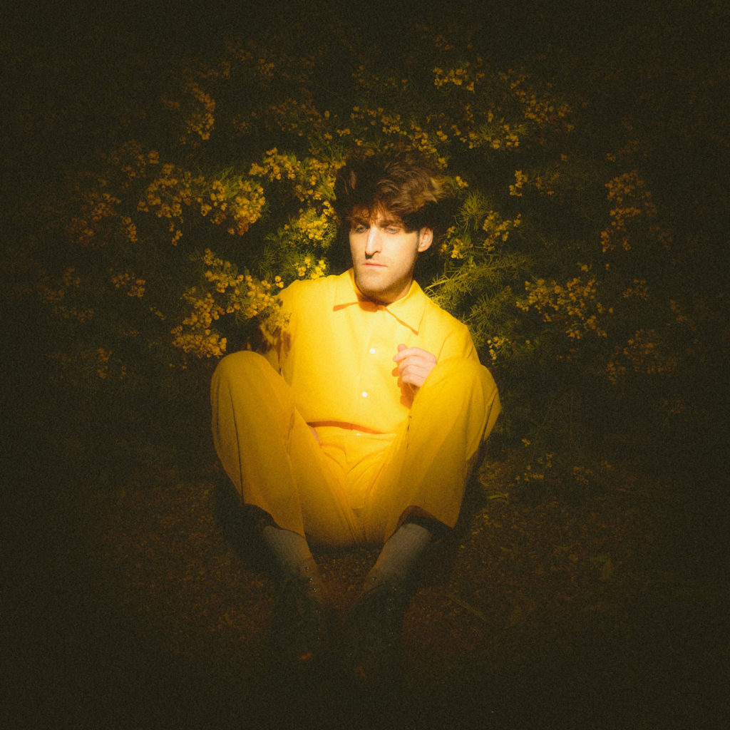 Dressed in yellow, Clay James of WHALES•TALK sits in flowers on the cover of the alternative project&squot;s EP, "Eternal Sunshine." (Courtesy of WHALES•TALK)