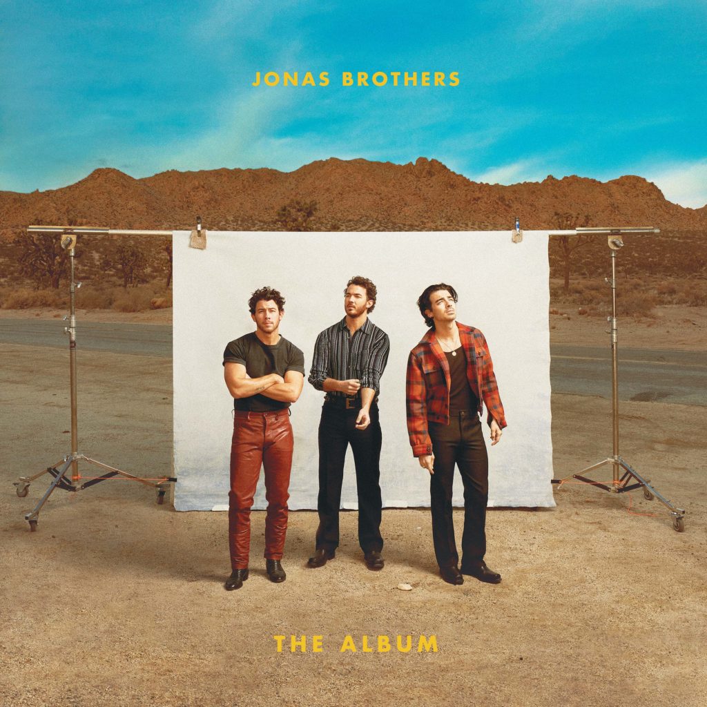 From left to right Nick, Kevin and Joe Jonas stand in front of a staged white backdrop set in the middle of a desert setting on the cover of the Jonas Brothers&squot; sixth album, titled "The Album." (Courtesy of Republic Records)