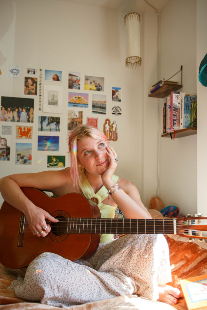 Bacino rests her head in her hand while playing the guitar. Bacino said she hopes her music can empower those who may feel lost. (Ella Greenberg Winnick/Daily Bruin)