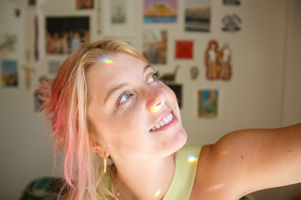 Bacino looks to the right as a rainbow reflects on her face. The singer-songwriter will perform her song titled "Regina and the Lion" when she competes at this year&squot;s Spring Sing. (Ella Greenberg Winnick/Daily Bruin)