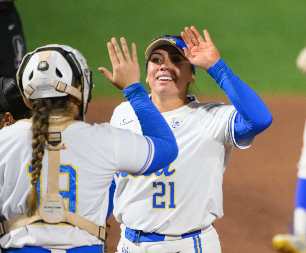 Sixth-year pitcher Brooke Yanez of UCLA softball high-fives redshirt junior catcher Alyssa Garcia before returning to the dugout.