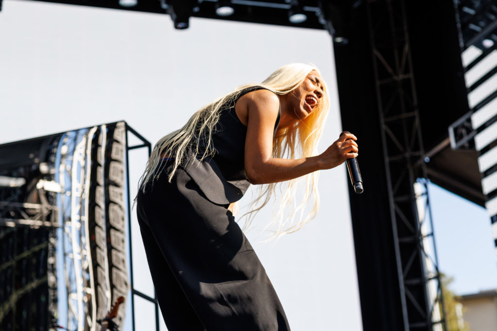 With dark formalwear contrasting her platinum blonde hair, Fousheé bends over the mic during her performance. The singer-songwriter&squot;s setlist included songs from her 2022 album "softCORE." (Anika Chakrabarti/Photo editor)
