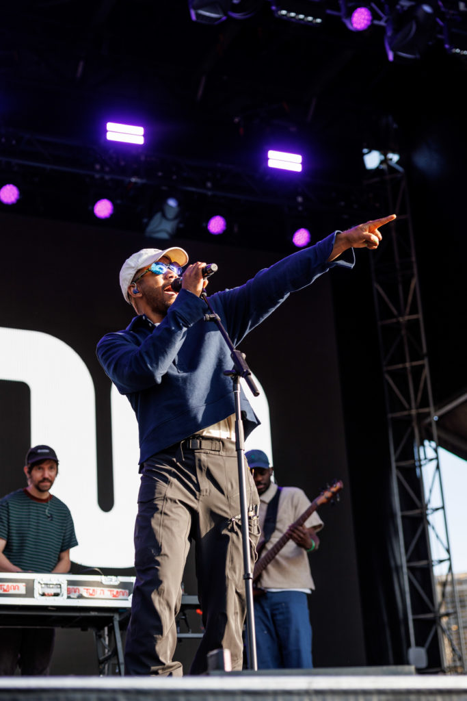 Gripping his mic stand, Toro y Moi points on the Re:SET stage as golden hour approaches. The singer later removed his cap and sunglasses as he smiled while the audience sang “Ordinary Pleasure.” (Anika Chakrabarti/Photo editor)