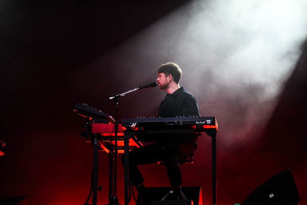 James Blake sits with his lower half drenched in red light as a cloud of white haze floats behind his head. The English musician played the keyboard during his performance of “Say What You Will.” (Anika Chakrabarti/Photo editor)