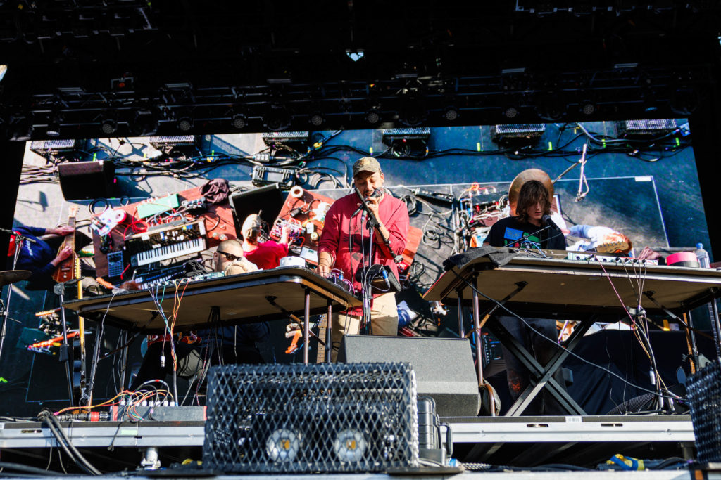 Musician Dijon stands atop the stange amidst a tangle of colorful wires and devices spread across two tables. The day two performer used the onstage instruments throughout his set, which included songs from his album "Absolutely." (Anika Chakrabarti/Photo editor)