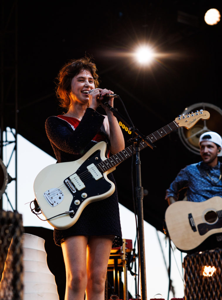 Clairo clutches the microphone in two hands as an amber light illuminates her. The bedroom pop singer brought tracks from her 2021 album to the Pasadena stage and covered Carole King’s “Bitter with the Sweet.” (Anika Chakrabarti/Photo editor)