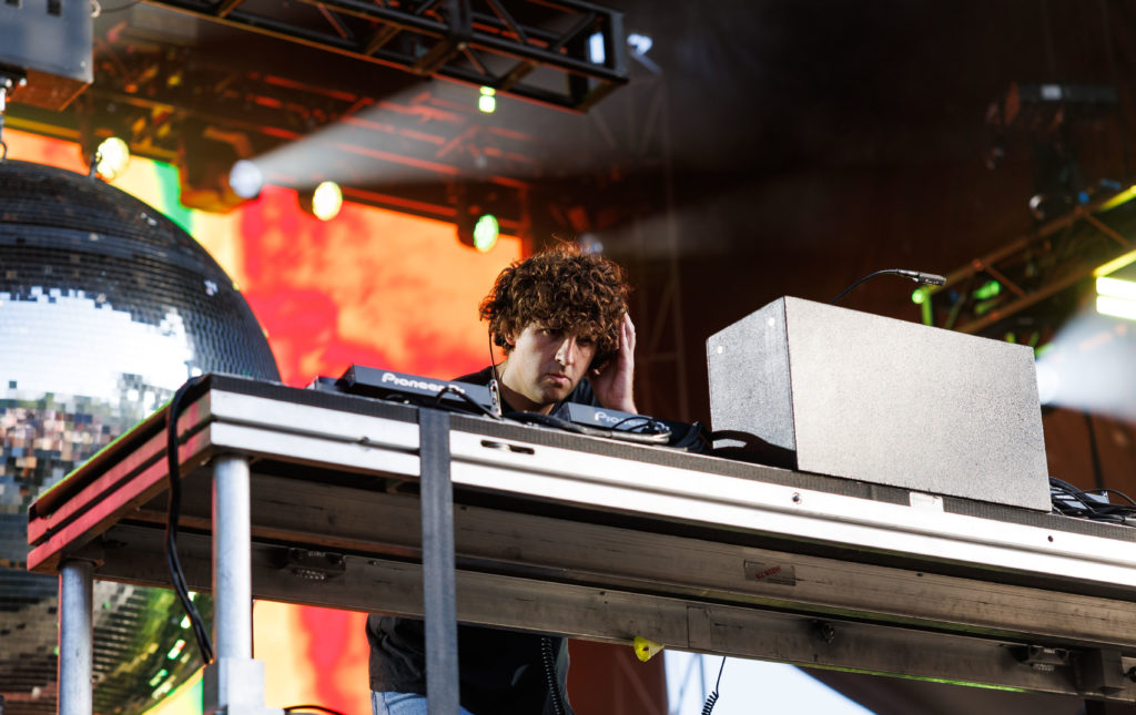 Seated at the DJ table, Jamie xx holds his hand to his headphones as a large discoball looms in the background. The British musician's performance consisted of multiple mashups with EDM and extraterrestrial soundscapes. (Anika Chakrabarti/Photo editor)