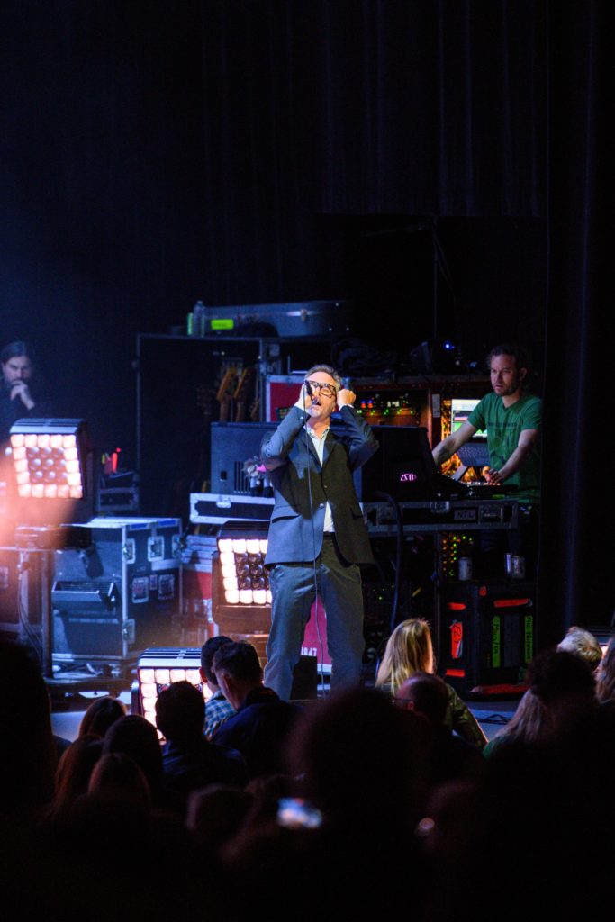 Matt Berninger leans back with his wired microphone in hand. The frontman danced and posed on stage alongside vunerable vocals during the band&squot;s second Los Angeles show on its "First Two Pages of Frankenstein Tour." (Neha Krishnakumar/Daily Bruin)