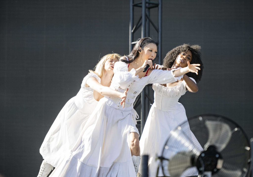 Held by two dancers in flowing white dresses, Rina Sawayama reaches out. The Japanese-British musician made a statement about racism leading up to her performance of "STFU!" (Megan Cai/Daily Bruin senior staff)