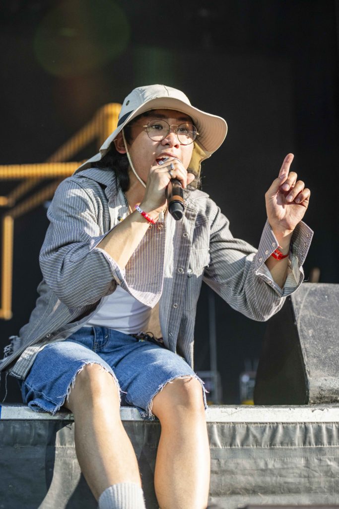 grentperez sits on the edge of the stage wearing a khaki hat and denim shorts. Audiences danced and swayed during the Australian singer-songwriter's Head in the Clouds debut. (Megan Cai/Daily Bruin senior staff)