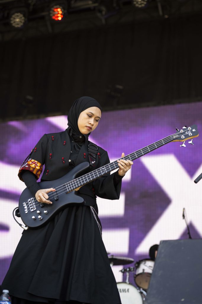 Bassist Widi looks at her instrument. Vocalist and guitarist Marsya said the group is happy to hear they are an inspiration, especially for girls, and they hope to see the rise of more female bands. (Megan Cai/Daily Bruin senior staff)