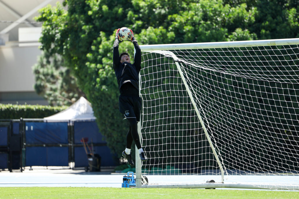Sutherland jumps high and reaches to catch the ball. (Courtesy of UCLA Athletics)