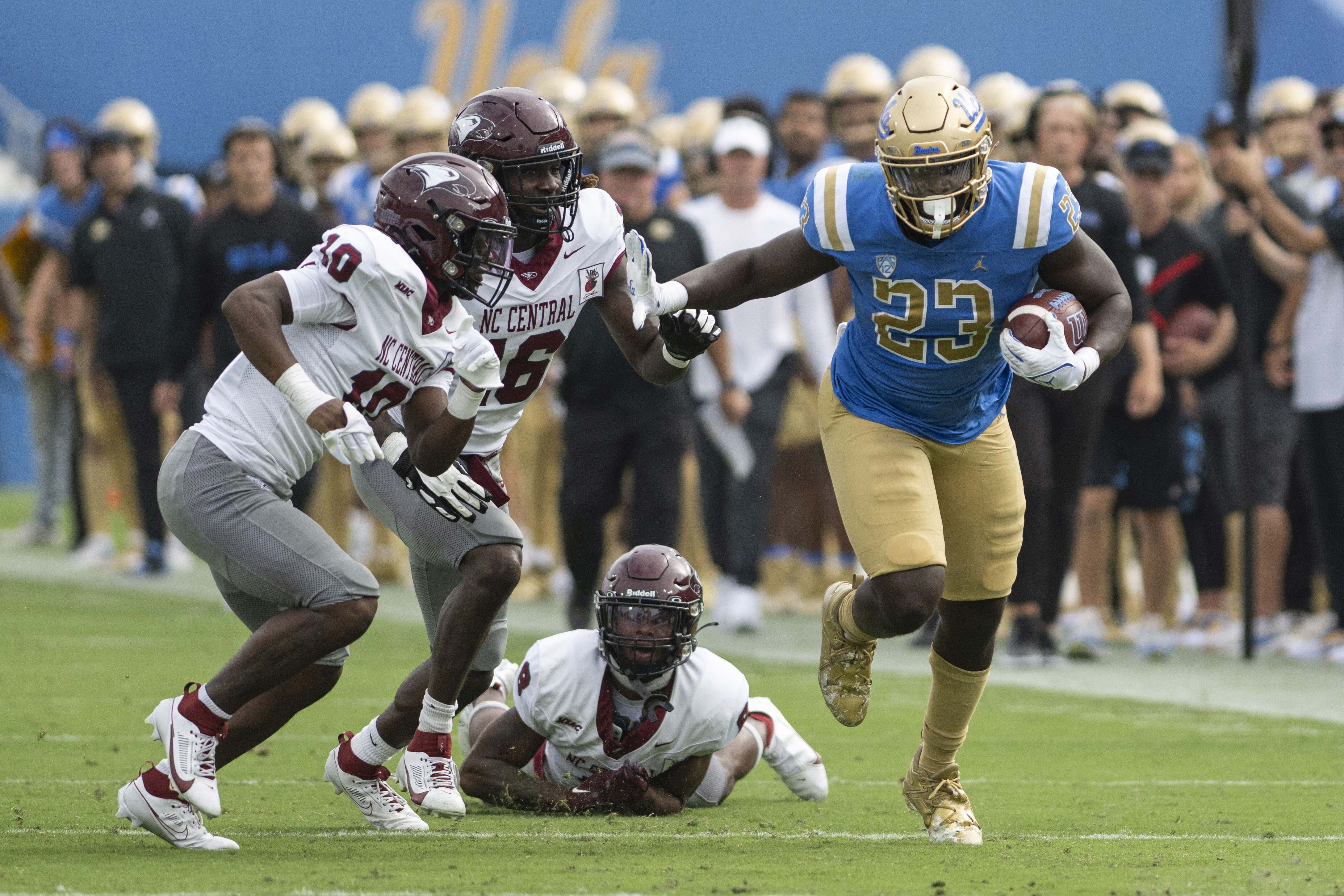 Redshirt junior running back Anthony Adkins sprints past three NC Central defenders. Adkins was UCLA football’s leading rusher on Saturday. (Brandon Morquecho/Assistant Photo editor)