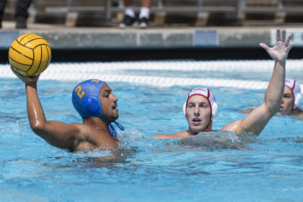 Redshirt freshman attacker Frederico Jucá Carsalade holds the ball up during an attack against No. 6 Stanford at Spieker Aquatics Center on Saturday. (Julia Zhou/Assistant Photo editor)