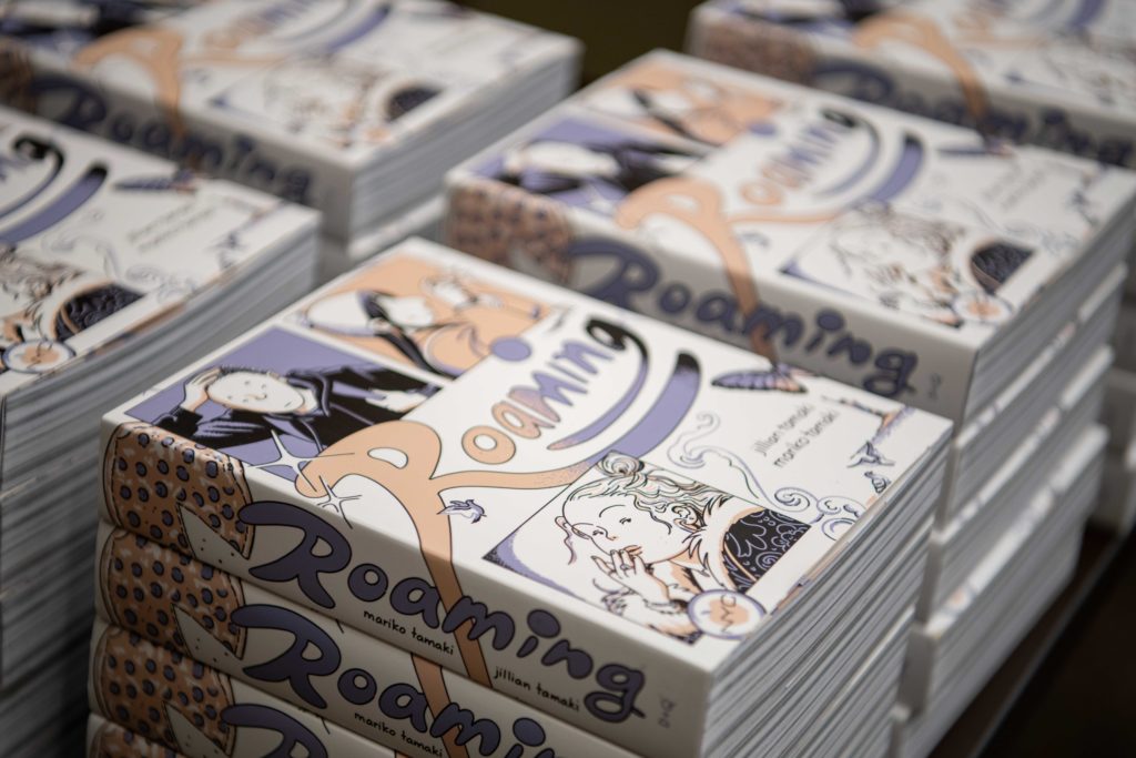 Copies of "Roaming" are pictured. Co-written by Jillian Tamaki and Mariko Tamaki, the graphic novel explores topics such as longterm friendships and queer romance. (Nicolas Greamo/Daily Bruin senior staff)