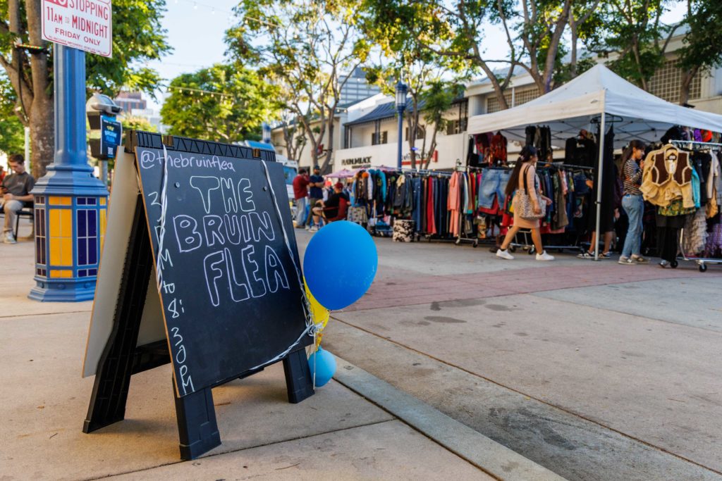 Pictured is a sign in front of vendor booths at Bruin Flea. The flea market was conceptualized by event director and UCLA alumus Luis Lopez. (Shane Yu/Daily Bruin staff)