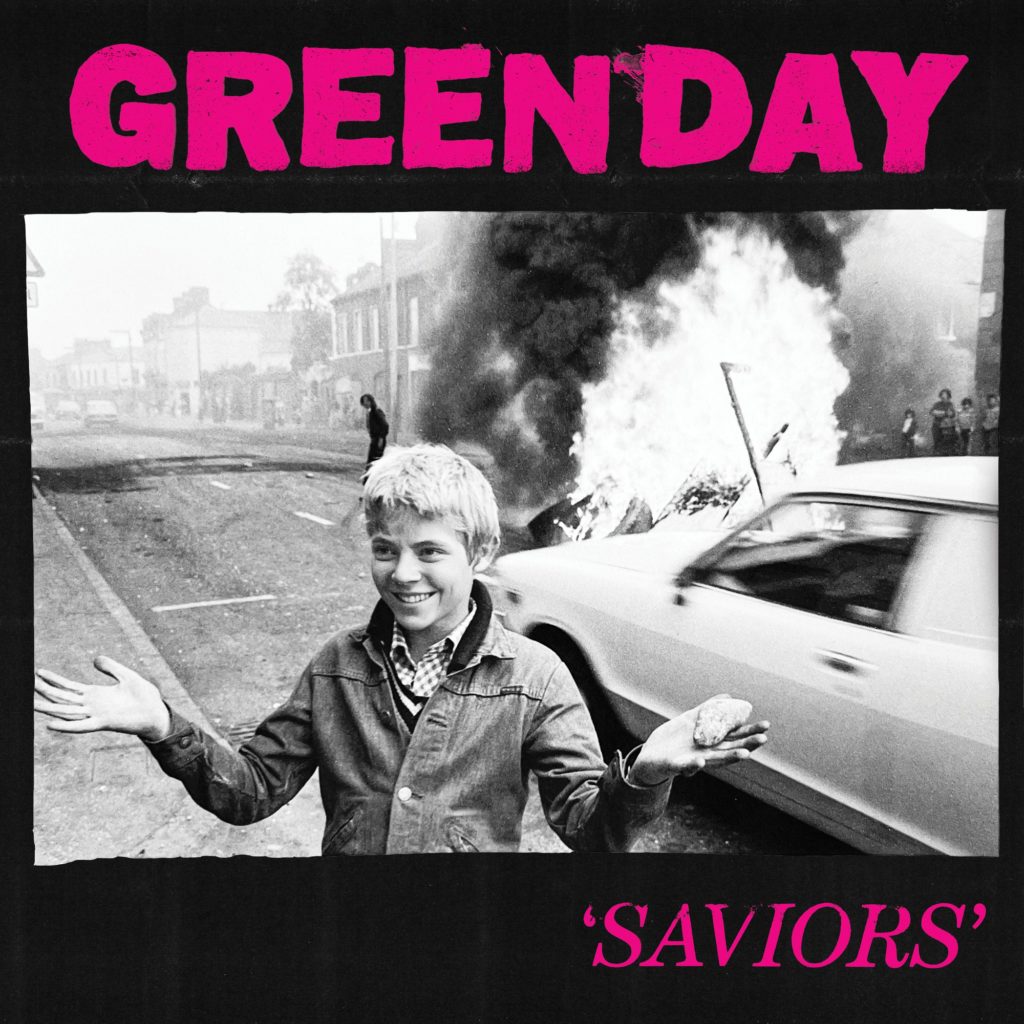 A greyscale image of an individual in front of a burning car comprises the center of the "SAVIORS" cover art. The latest Green Day album released today and includes the song "The American Dream Is Killing Me." (Courtesy of Reprise Records)
