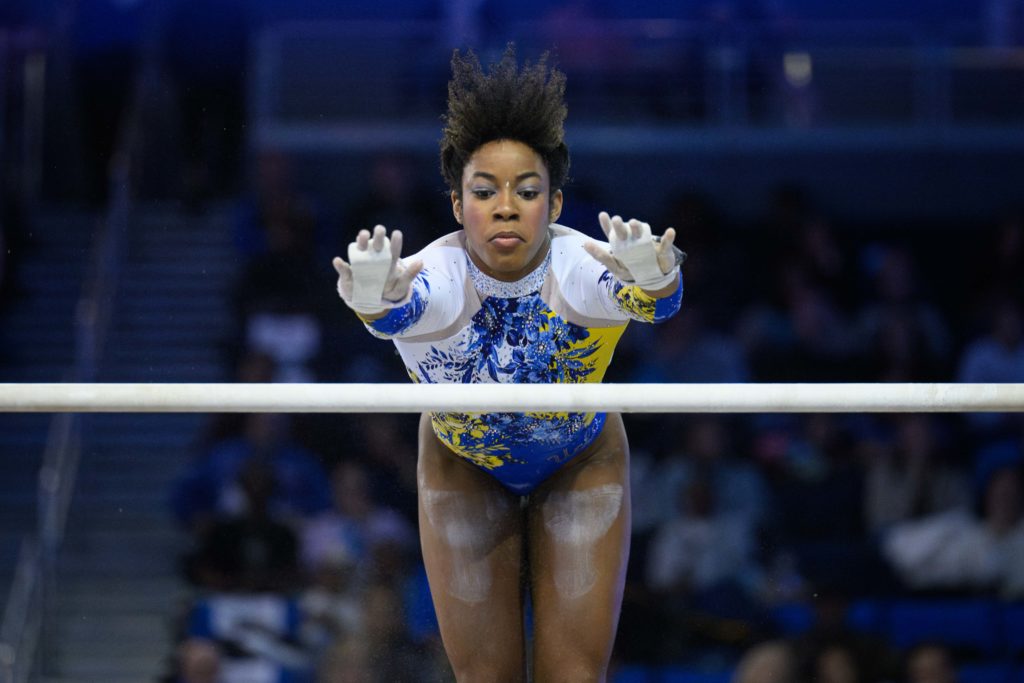Sophomore Maddie Anyimi soars in the air toward the high bar on bars at Pauley Pavilion. (Jeremy Chen/Photo editor)