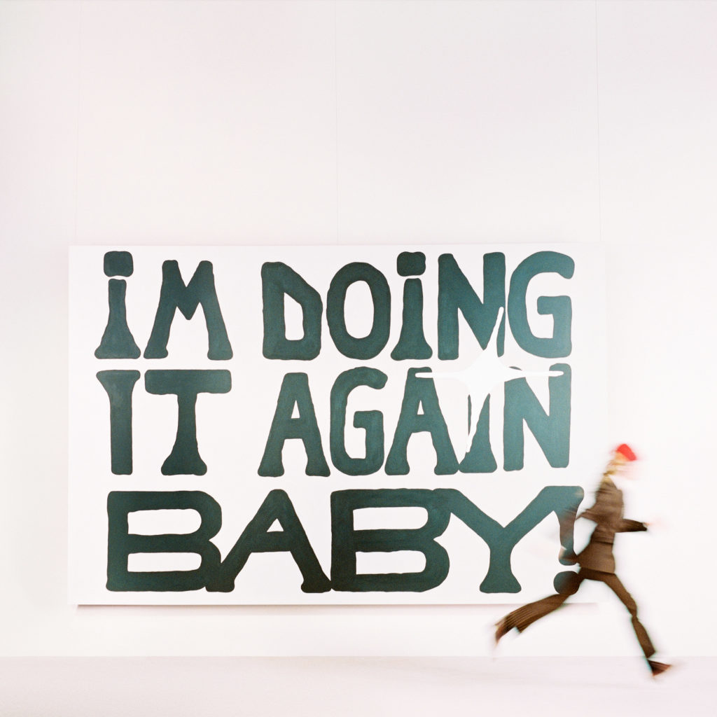 girl in red&squot;s sophomore album cover reads the title “I’M DOING IT AGAIN BABY!” as an individual sprints by. The April 12 release includes the prerelease tracks "Too Much" and "You Need Me Now?" the latter of which features pop starlett Sabrina Carpenter. (Courtesy of Columbia Records)