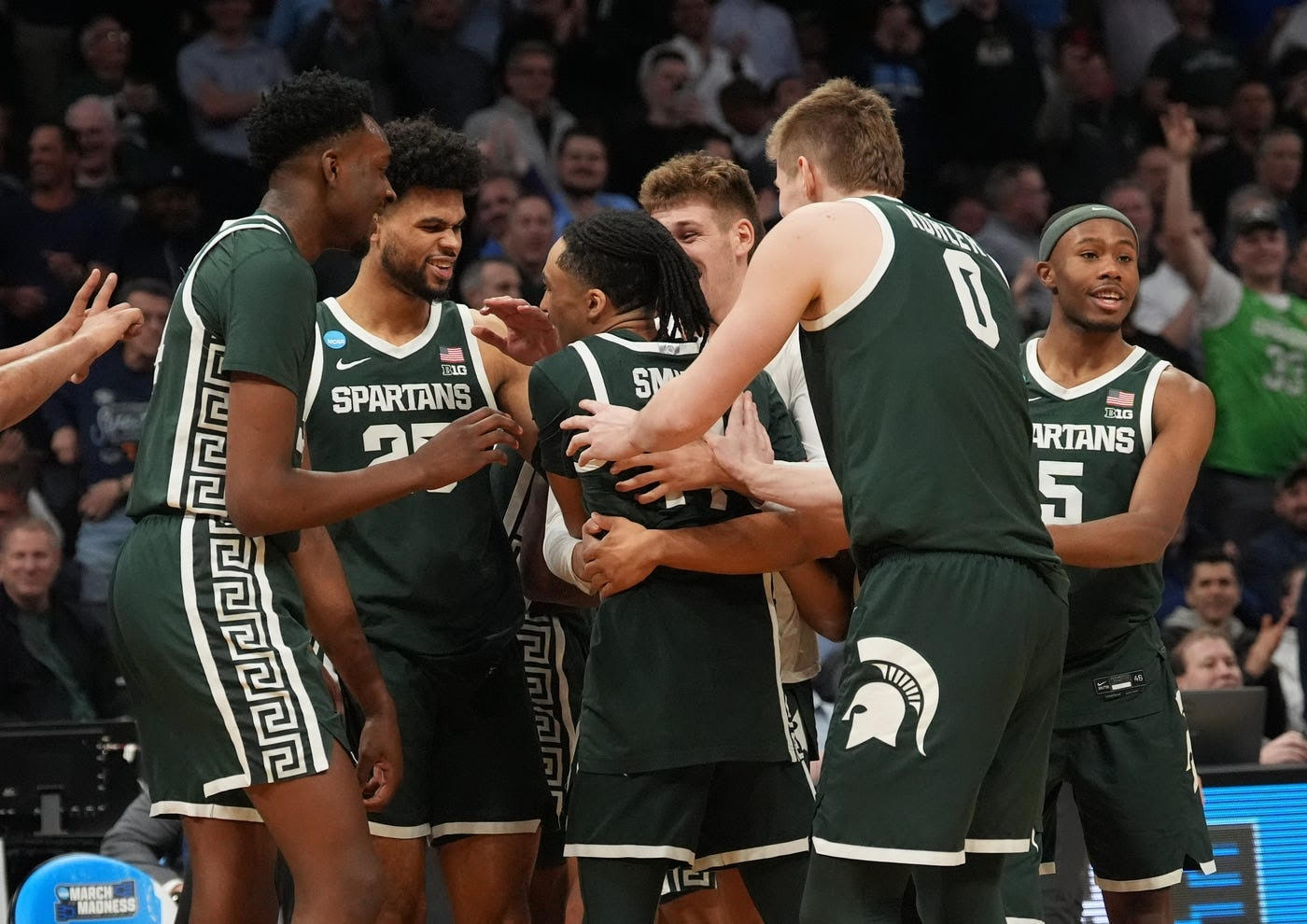 Guard Davis Smith receives embraces from his teammates on the court. (Courtesy of MSU Athletic Communications)