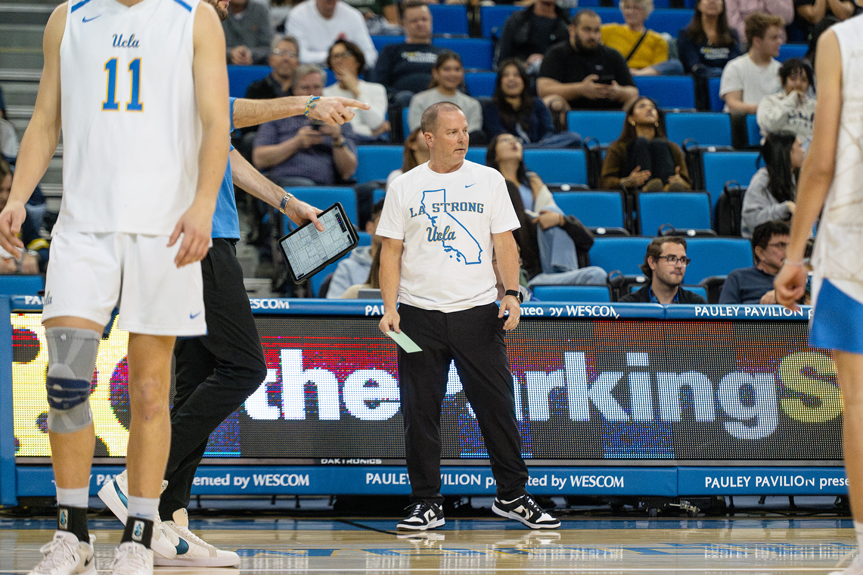 Coach John Hawks coaches from the sideline of Pauley Pavilion.