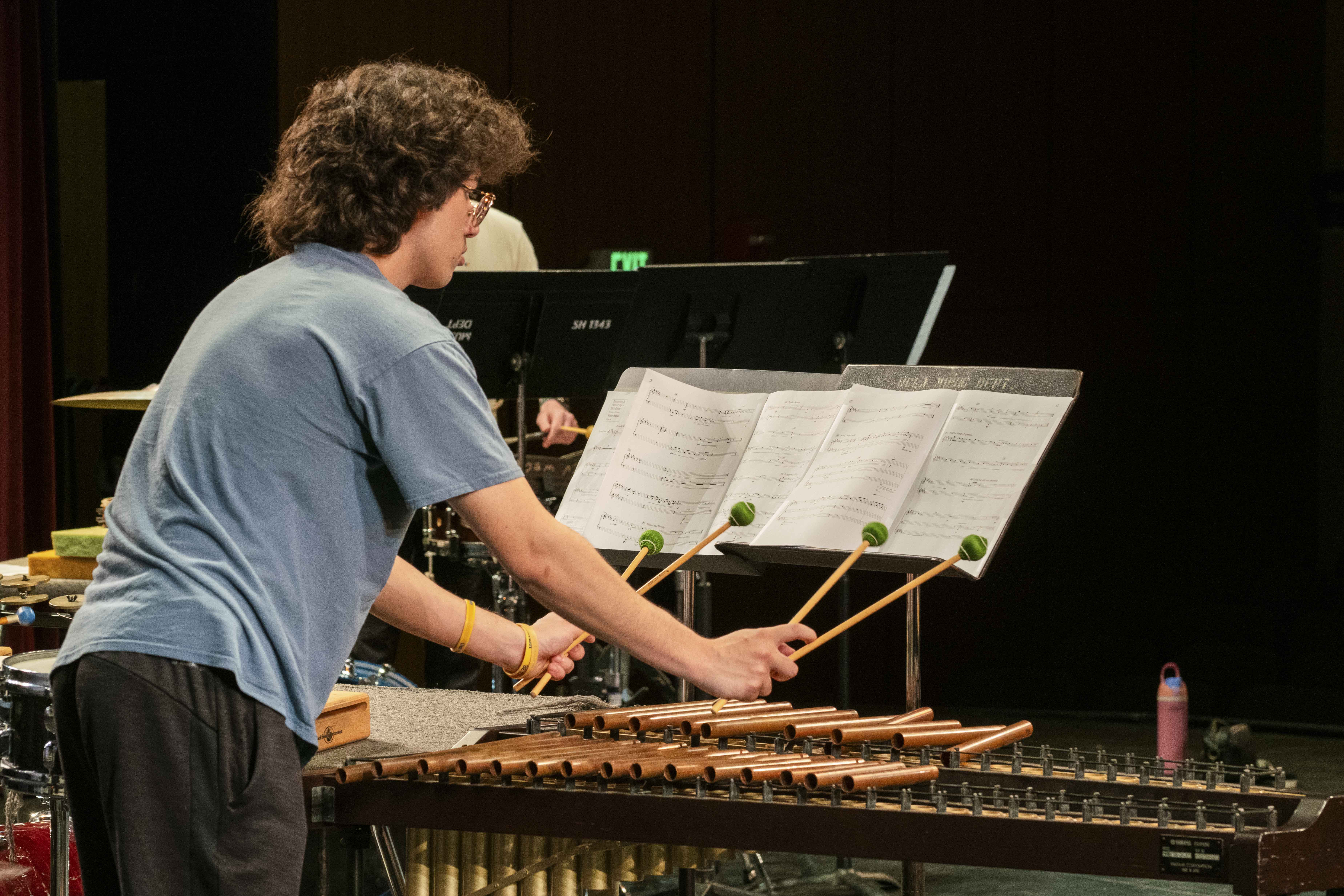 A student wearing a blue shirt reads music and performs at a UCLA Percussion Ensemble event. The winter recital on Monday will feature both historical music and more contemporary sounds, such as a rendition of Rush&squot;s song "YYZ." (Courtesy of The UCLA Herb Alpert School of Music)