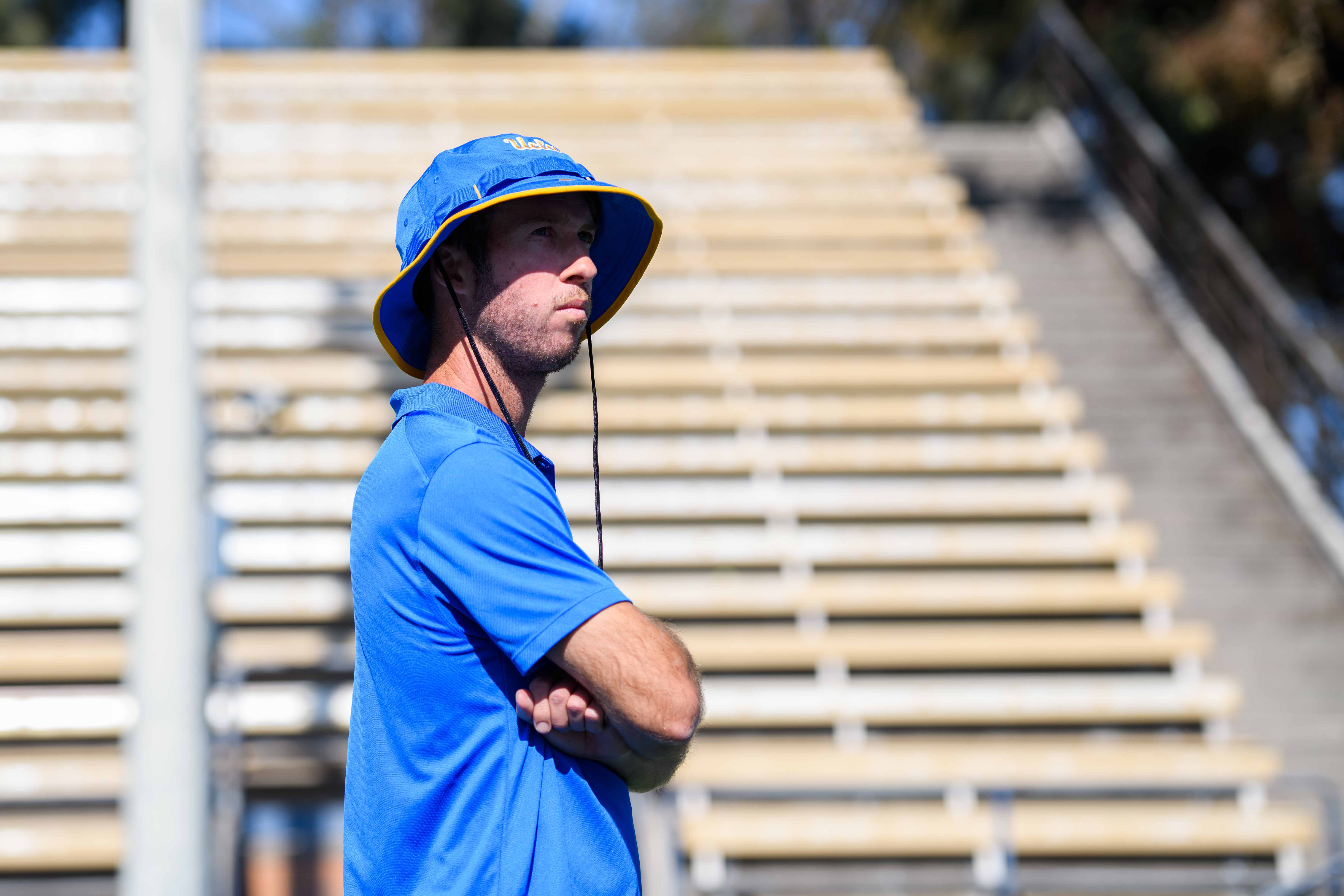 UCLA men's tennis assistant coach Wil Martin stands with his arms crossed at the Los Angeles Tennis Center. Martin competed alongside freshman Cassius Chinlund in the Pacific Coast Doubles Championship over the weekend, earning an appearance in the round of 16. (Brianna Carlson/Daily Bruin staff)