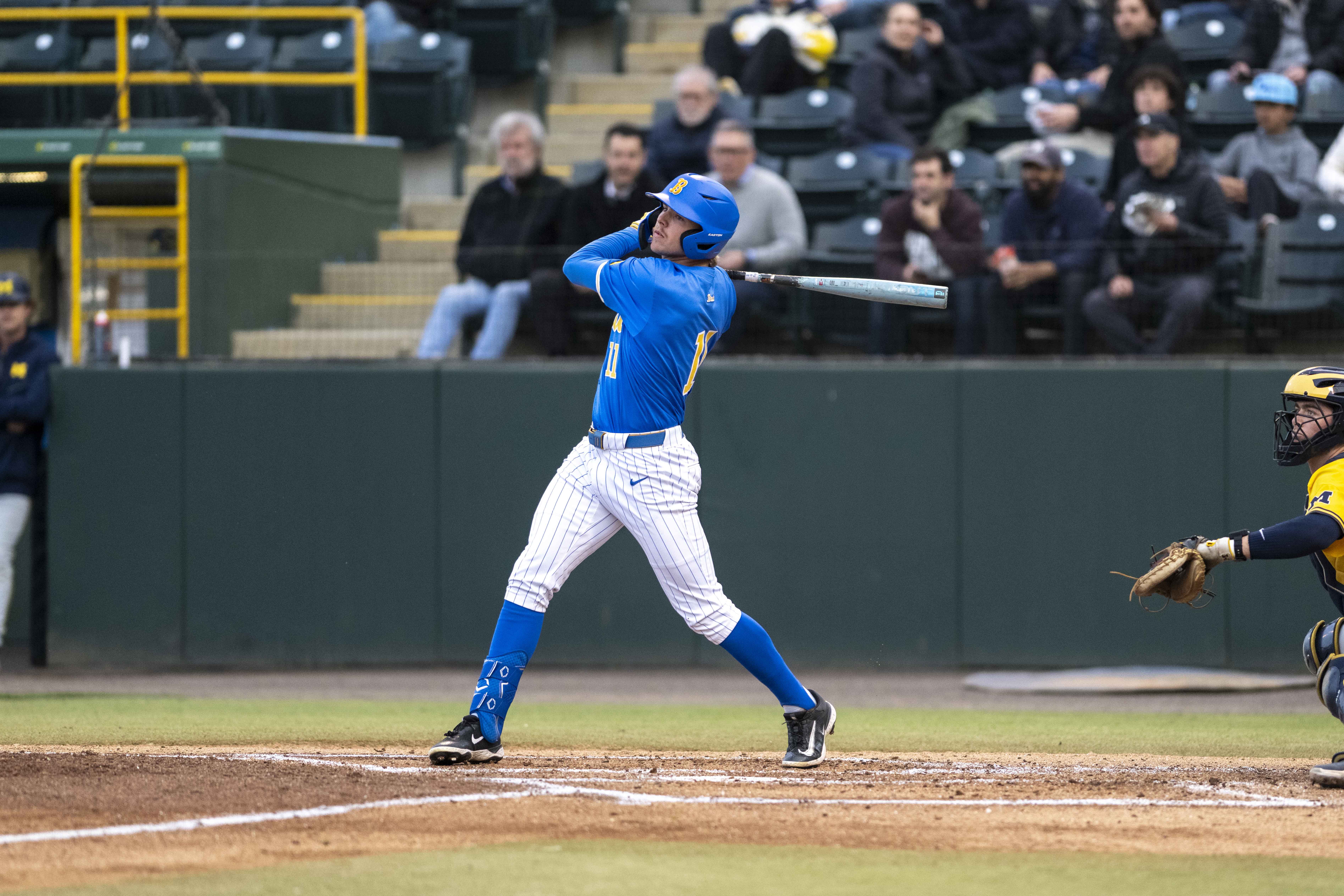 Payton Brennan hits a flyball at Jackie Robinson Stadium. The redshirt sophomore center fielder went 4-for-5 against Michigan. (Alexefrain Gonzales Diaz/Daily Bruin)