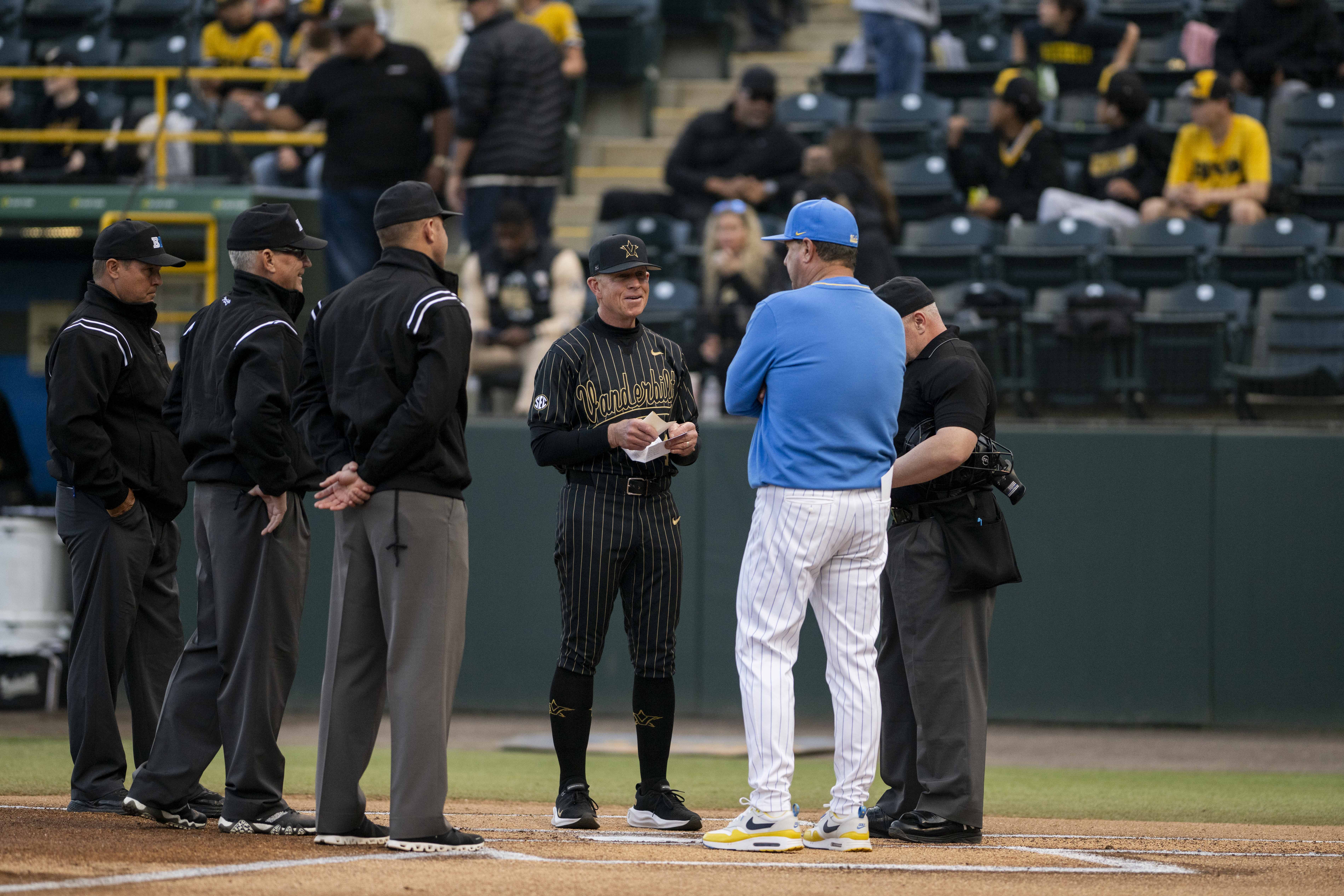 UCLA baseball coach John Savage and Vanderbilt coach Tim Corbin meet at home plate before first pitch Feb. 28. Savage and Corbin are the only two coaches to have won a College World Series and produced a No. 1 overall MLB Draft pick, Golden Spikes Award winner and MLB Cy Young Award winner. (Rylan Riccabona/Daily Bruin)