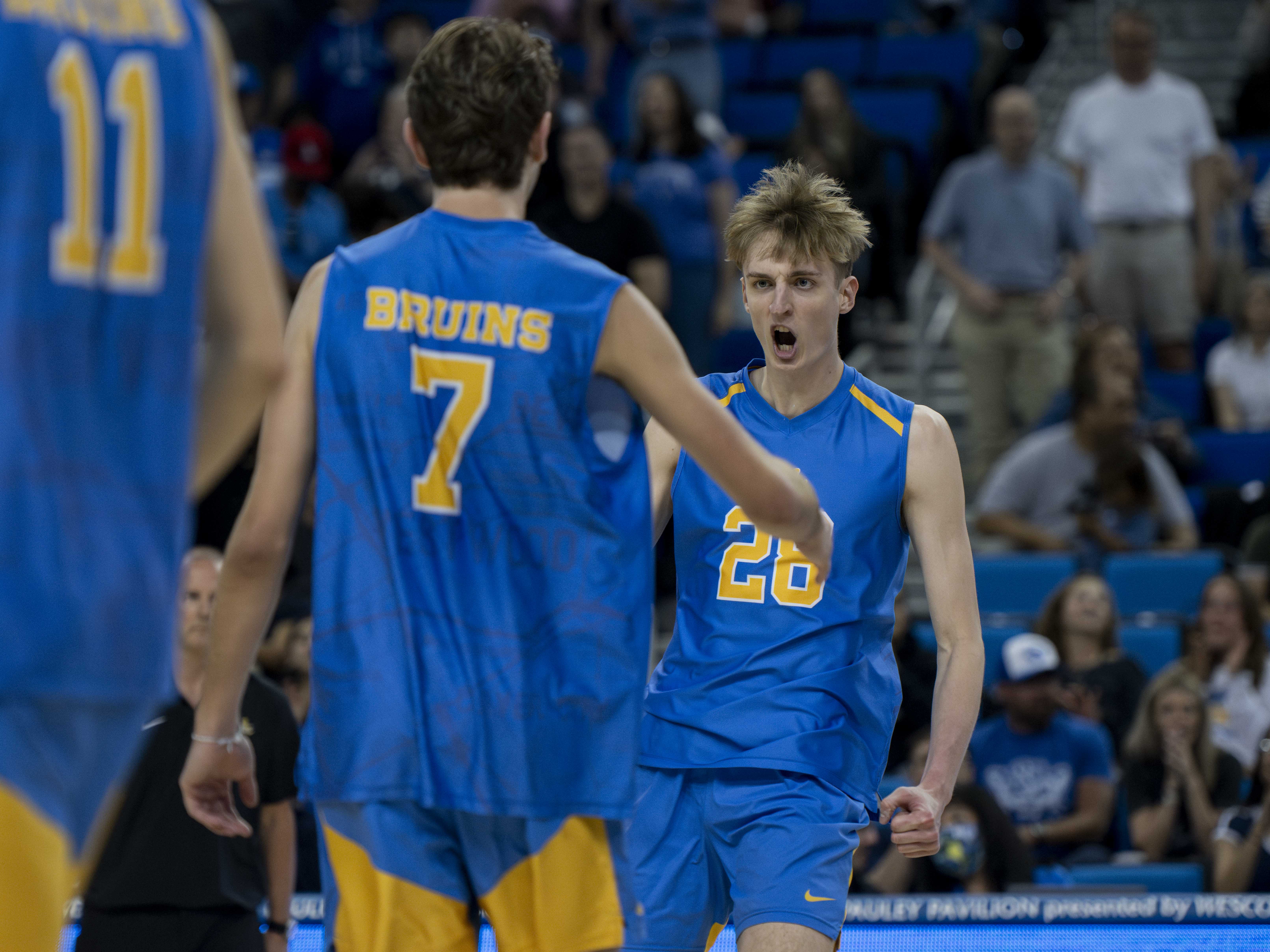 Junior Zach Rama yells in excitement as he high-fives junior setter Andrew Rowan. (Zimo Li/Photo editor)
