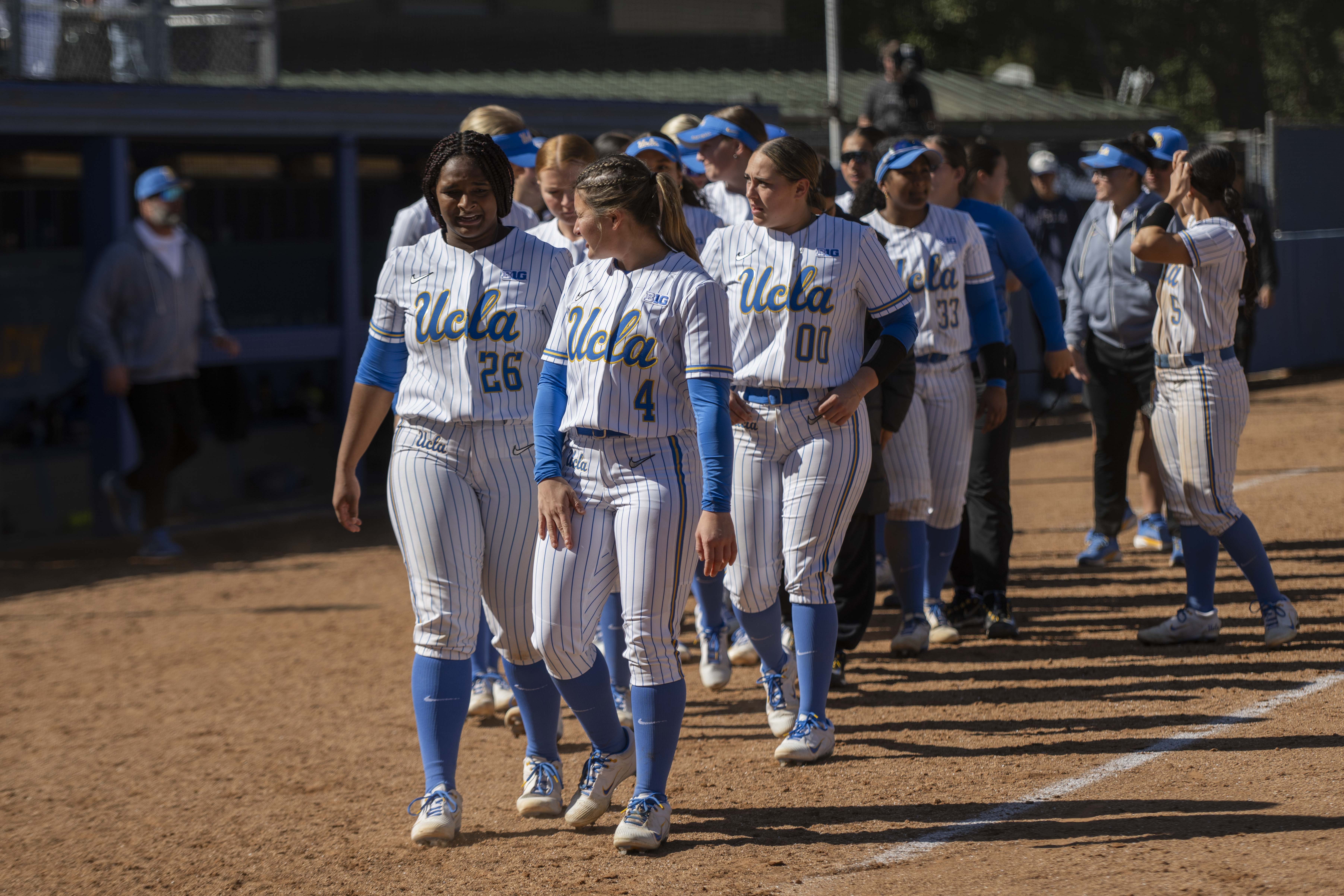 UCLA softball players walk up to home plate after a game. (Edward Ho/Daily Bruin)