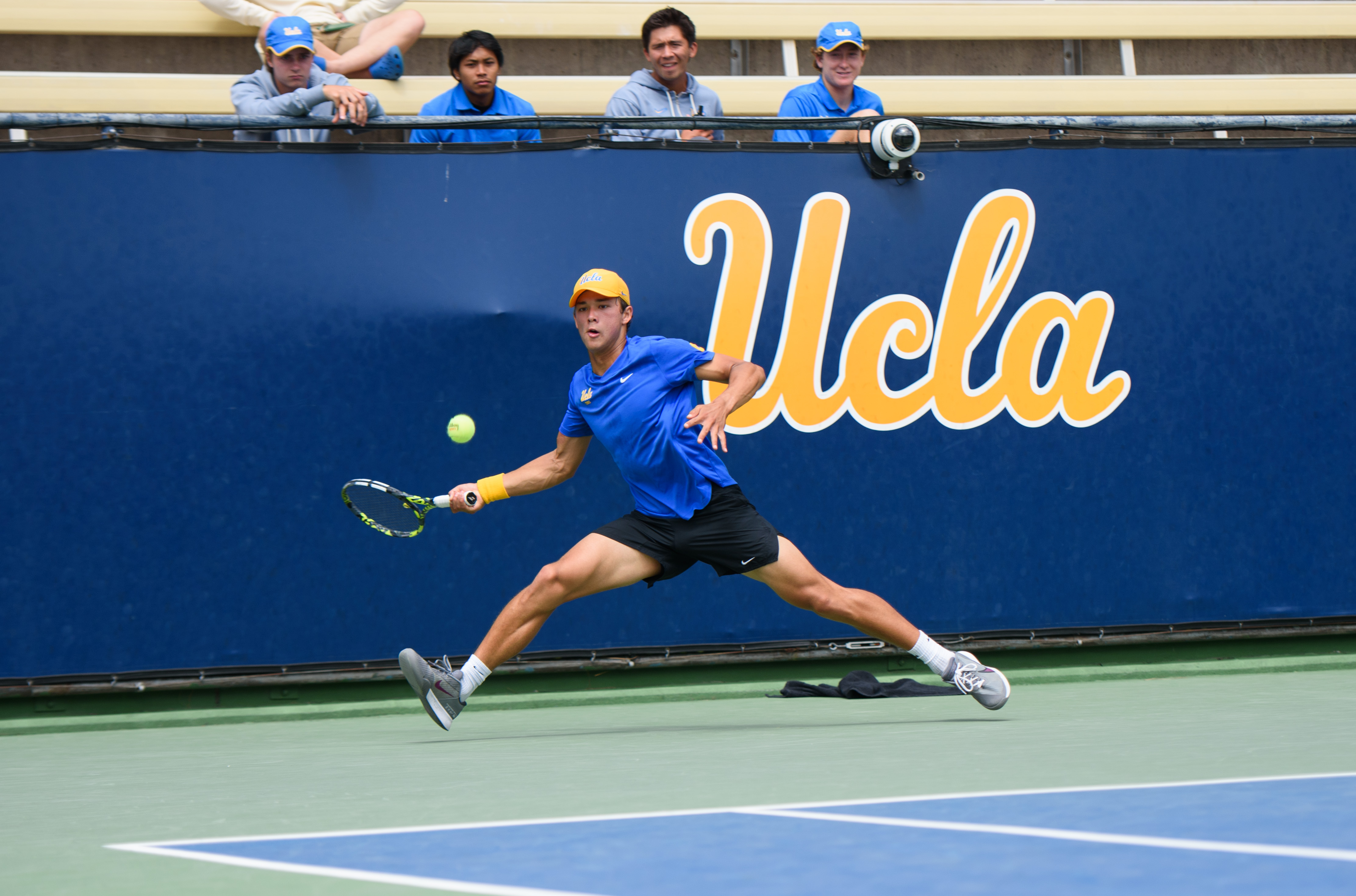 No. 110 redshirt sophomore Emon van Loben Sels lunges to his right as he attempts to forehand a ball. (Libby Li/Daily Bruin)