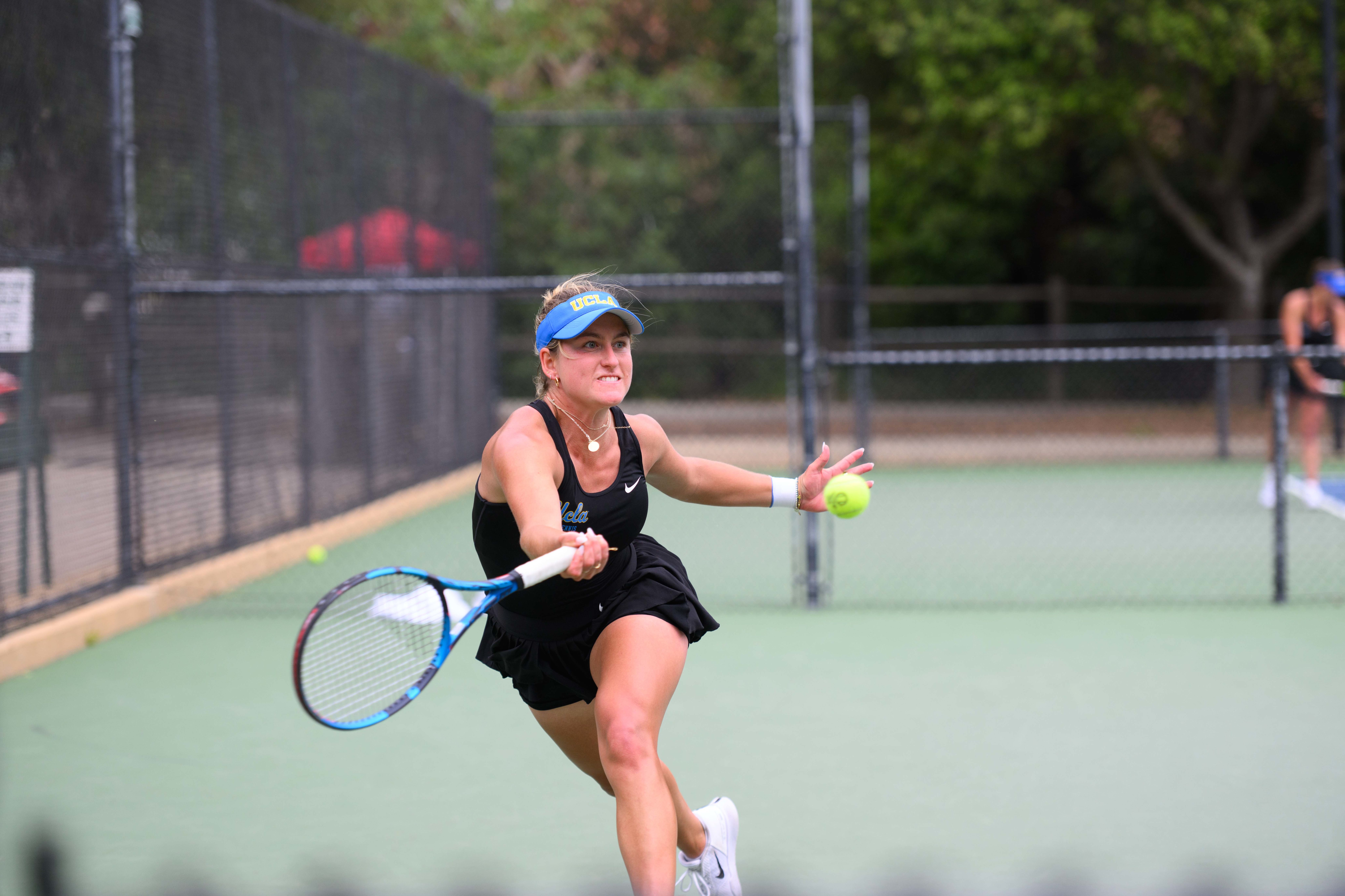 No. 31 junior Anne-Christine Lutkemeyer extends her right arm forward in an attempt to forehand a ball. (Andrew Diaz/Daily Bruin)