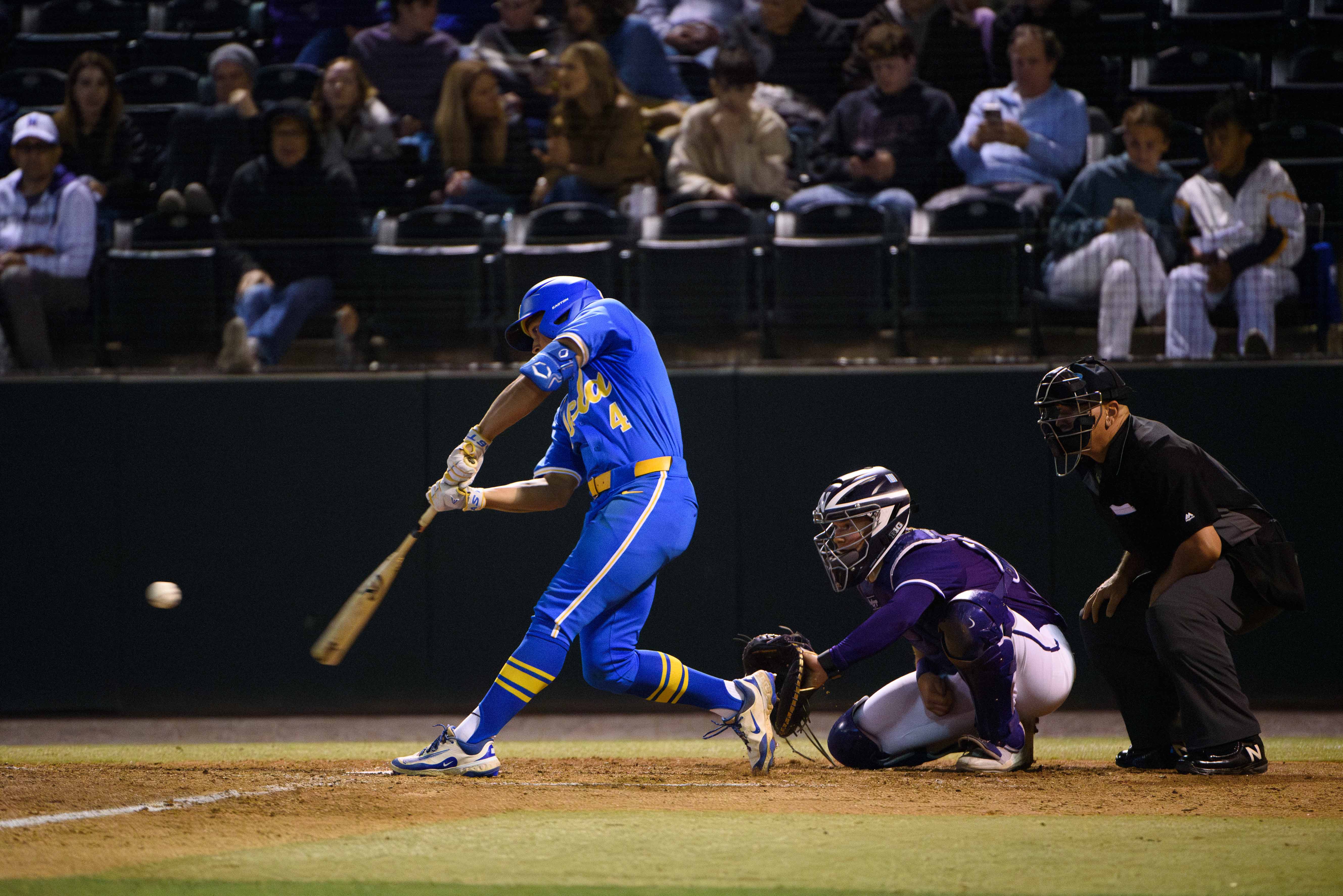 Sophomore second baseman Phoenix Call swings at a knee-high pitch. (Libby Li/Daily Bruin)