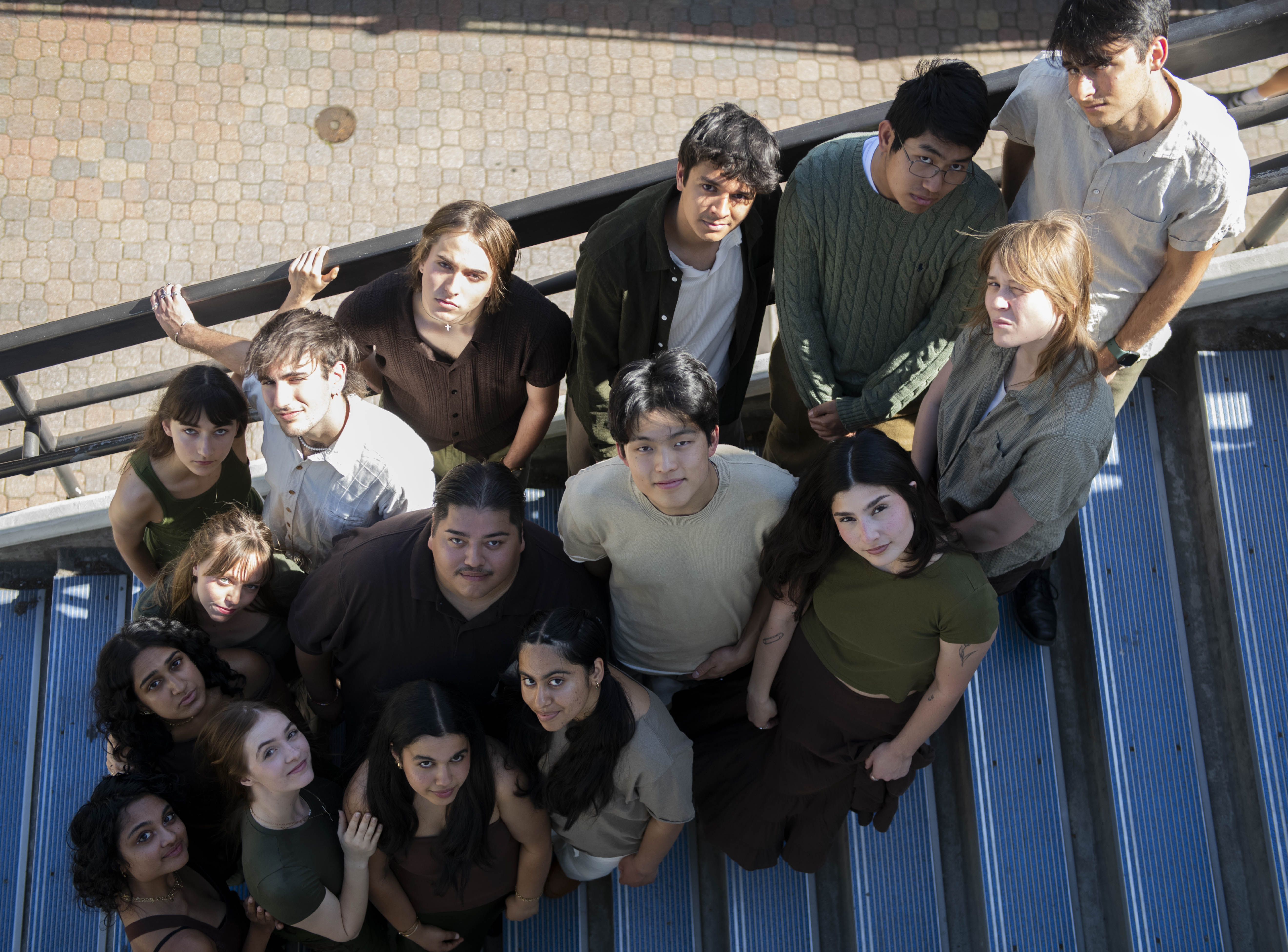 Members of Awaken A Cappella stand together on a blue staircase and look upward toward the camera. The group's performance at Spring Sing on Friday will be its first appearance at the talent competition since 2018. (Karla Cardenas-Felipe/Daily Bruin staff)