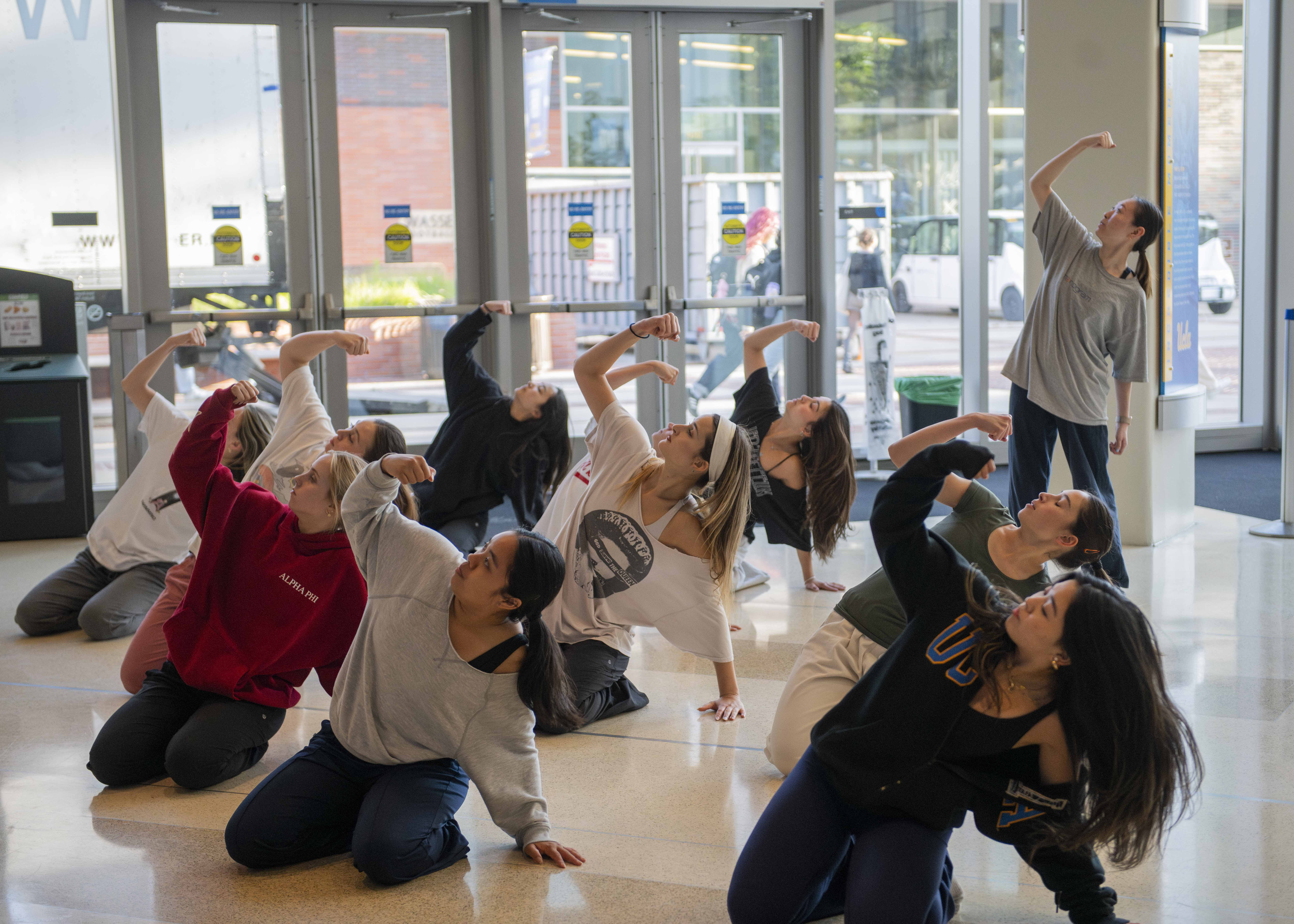 Members of Icarus Contemporary dance together with synchronized movements while each dancer raises their right arm. The troupe had to balance preparing for its year-end showcase, which took place May 10, with practicing for Spring Sing. (Anna Dai-Liu/Daily Bruin senior staff)