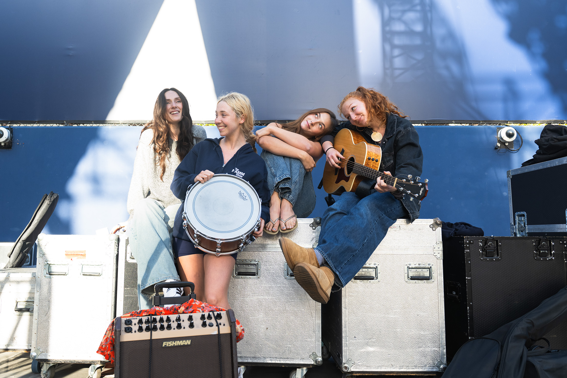 Ryann Barnes and her bandmates sit atop stage equipment against a blue backdrop. The student singer-songwriter said her artistic influences include Imogen Heap, Dora Jar and The Japanese House. (Darlene Sanzon/Assistant Photo editor)
