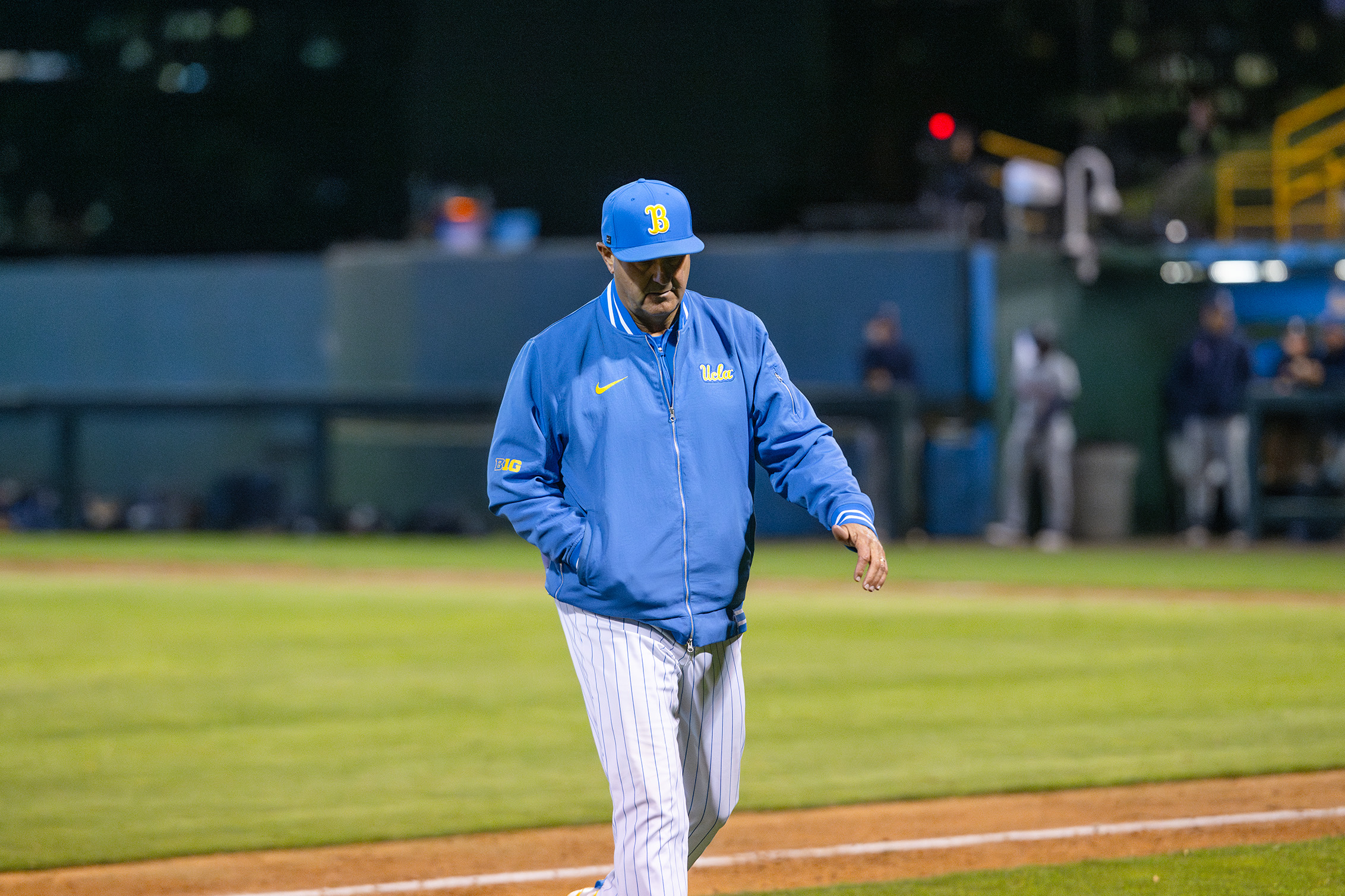 Coach John Savage walks from the mound to the Bruins' dugout. (Jeannie Kim/Daily Bruin senior staff)