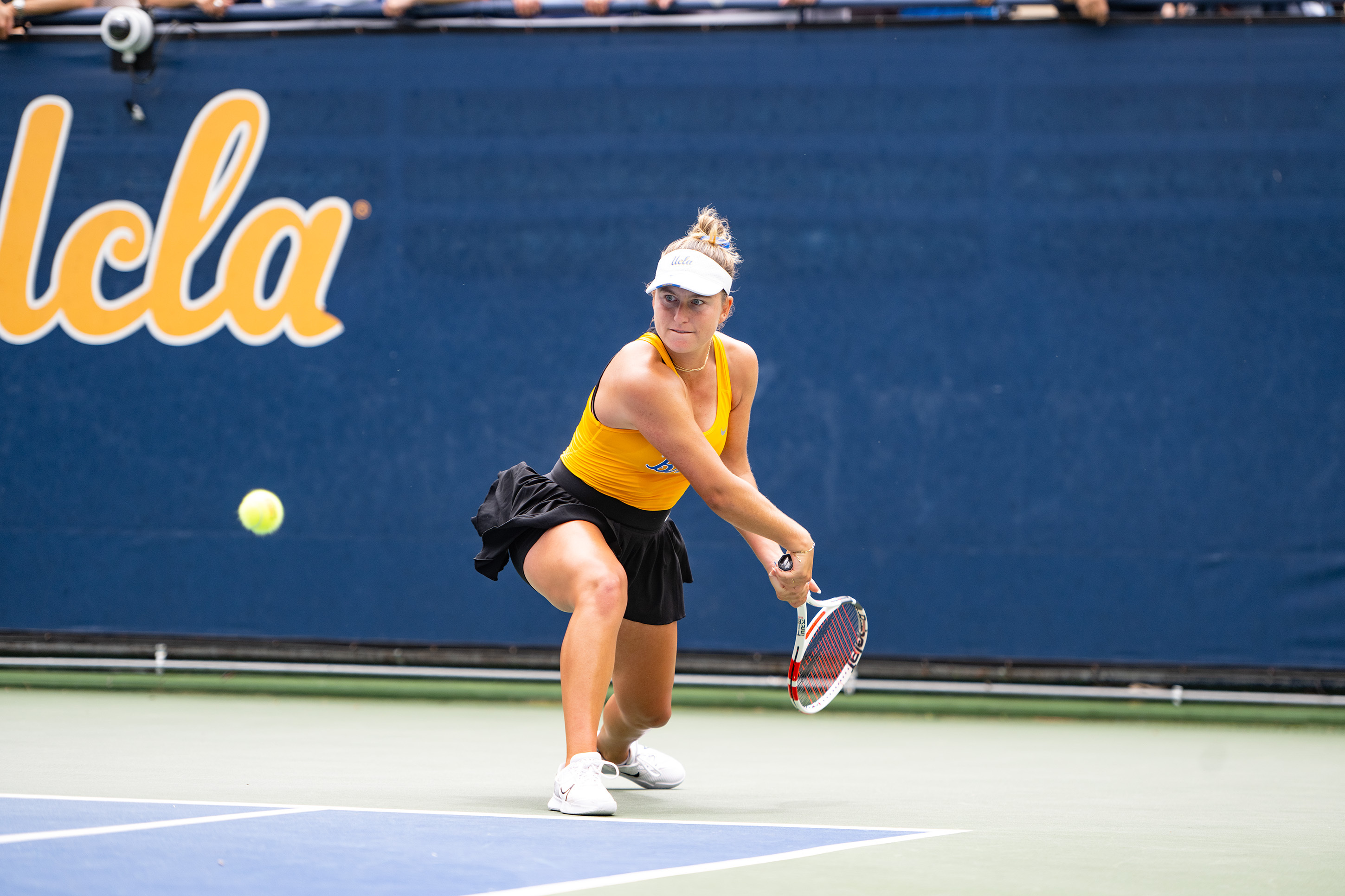 No. 31 junior Anne-Christine Lutkemeyer bends her knees to backhand a sinking ball. (Nicolas Greamo/Daily Bruin senior staff)